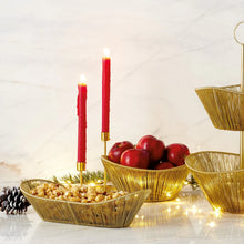 Load image into Gallery viewer, Decorative setup with gold bowls, red candles, and apples on a white surface.
