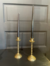 Load image into Gallery viewer, Two tall candlesticks with brass bases on a dark surface.
