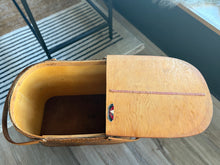 Load image into Gallery viewer, Open wood and wicker picnic basket with a visible brand logo on a wooden floor.
