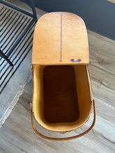 Load image into Gallery viewer, Open wood and wicker picnic basket with a brand logo on a wooden floor
