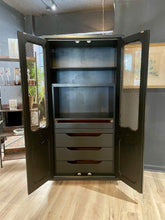 Load image into Gallery viewer, Tall wood black cabinet with open doors in a room setting
