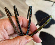 Load image into Gallery viewer, Four bangle bracelets with gemstone accents held by a hand against a blurred background
