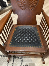 Load image into Gallery viewer, Wooden rocking chair with a quilted black leather seat pad on a patterned rug.
