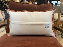 Load image into Gallery viewer, White pillow with brown trim on a brown cushion, with a visible tag.
