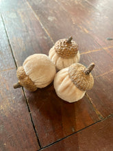 Load image into Gallery viewer, Three fabric acorn decorations with textured brown tops and stems, arranged on a dark wooden tabletop.
