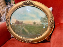 Load image into Gallery viewer, Small round painting of a landscape with a red barn, held in a gold frame.
