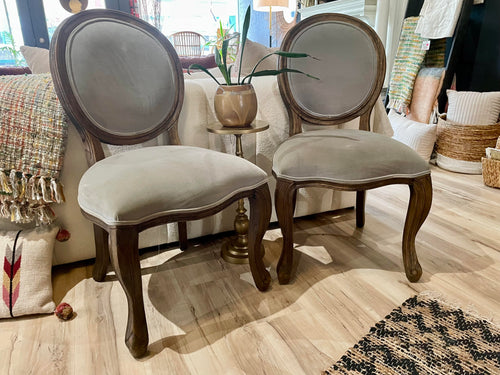 Two upholstered chairs in a room with decor elements.