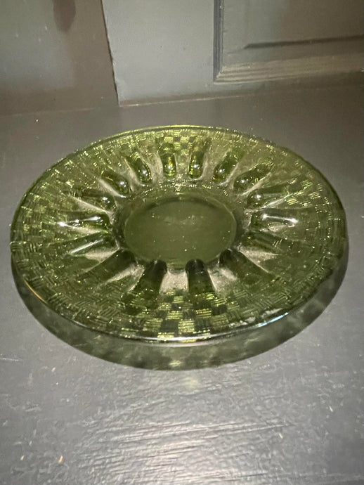 Decorative glass ashtray on a dark surface
