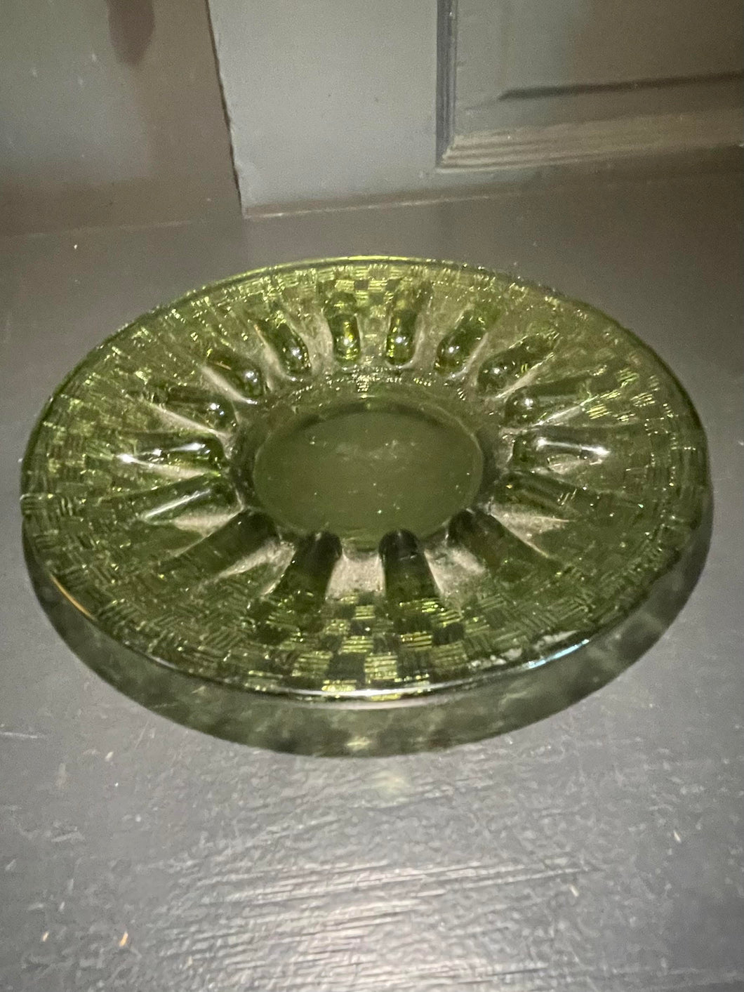 Decorative glass ashtray on a dark surface