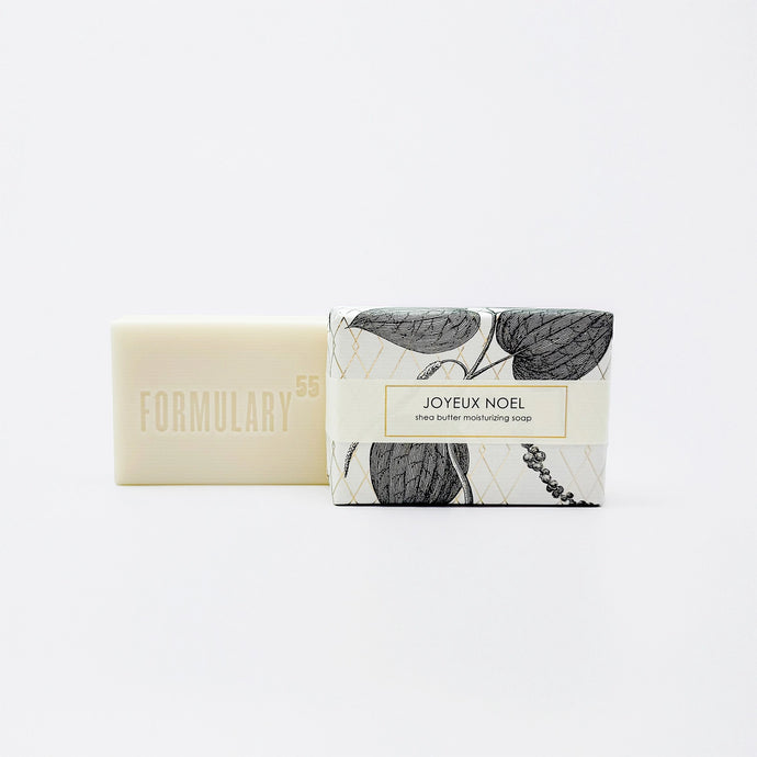 Bar of soap with botanical packaging labeled 'Formulary55 Joyeux Noel' on a white background