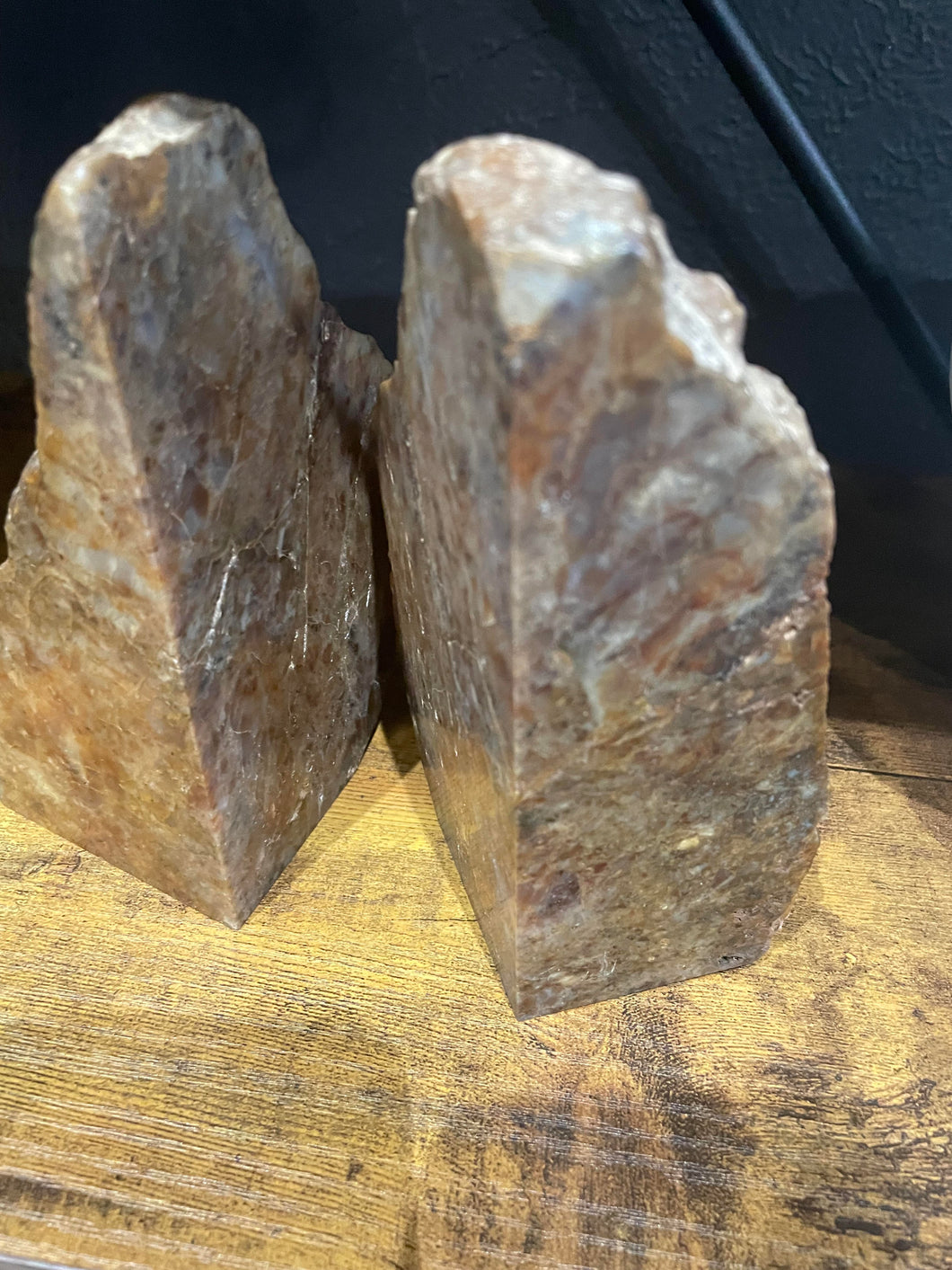 Two stone bookends on a wooden surface with a blurred background