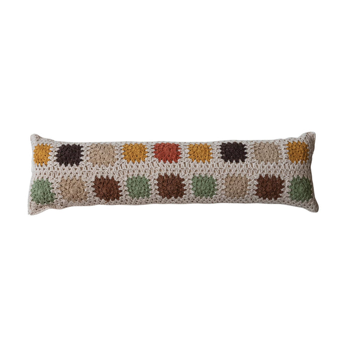 Crocheted pillow with a pattern of multicolored squares on a white background