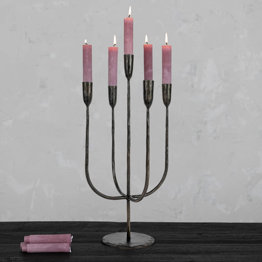 Candleabra with five pink candles on a gray background