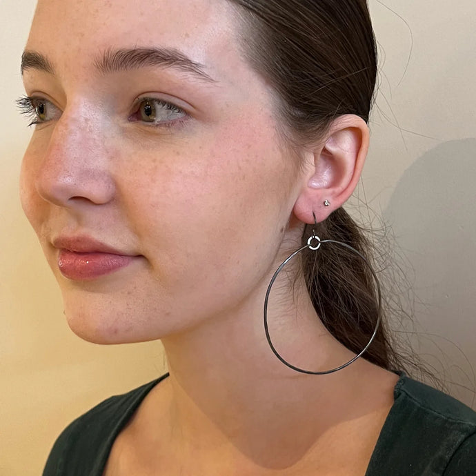 Sterling Silver 2.5 inch hoops suspended on Sterling Silver earring hook and oxidized sterling silver jump ring.