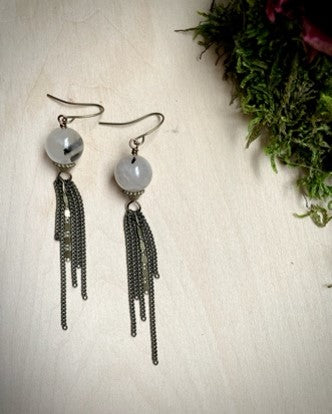 Tourmalinated quartz spheres hang from hook earrings and have multi chain hanging from the sphere