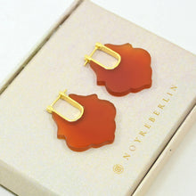 Load image into Gallery viewer, Pair of orange earrings with gold accents on a beige box with 'NOYRE BERLIN' branding.
