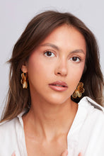 Load image into Gallery viewer, Woman wearing gold earrings against a plain background
