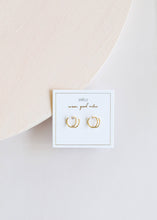Load image into Gallery viewer, Gold hoop earrings on a branded card with a soft pink background

