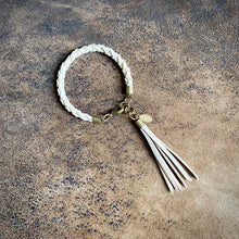 Load image into Gallery viewer, Braided bracelet with tassel on a textured surface
