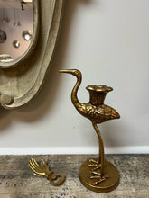 Load image into Gallery viewer, Gold crane candle holder on a wooden surface with a white wall in the background.
