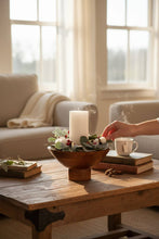 Load image into Gallery viewer, Hand touching a candle and wooden bowl, in a cozy living room setting.
