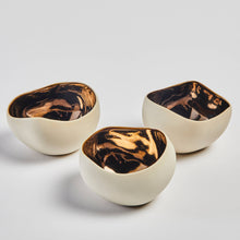 Load image into Gallery viewer, A set of three ceramic candle holders with a bronze interior and a muted beige exterior finish in a white surface
