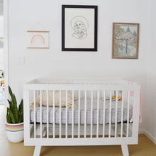 Load image into Gallery viewer, Nursery room with a white crib, framed artwork on the wall, and a plant.
