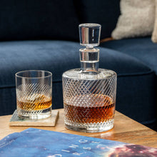 Load image into Gallery viewer, Whiskey decanter and glass on a table with a dark blue couch in the background
