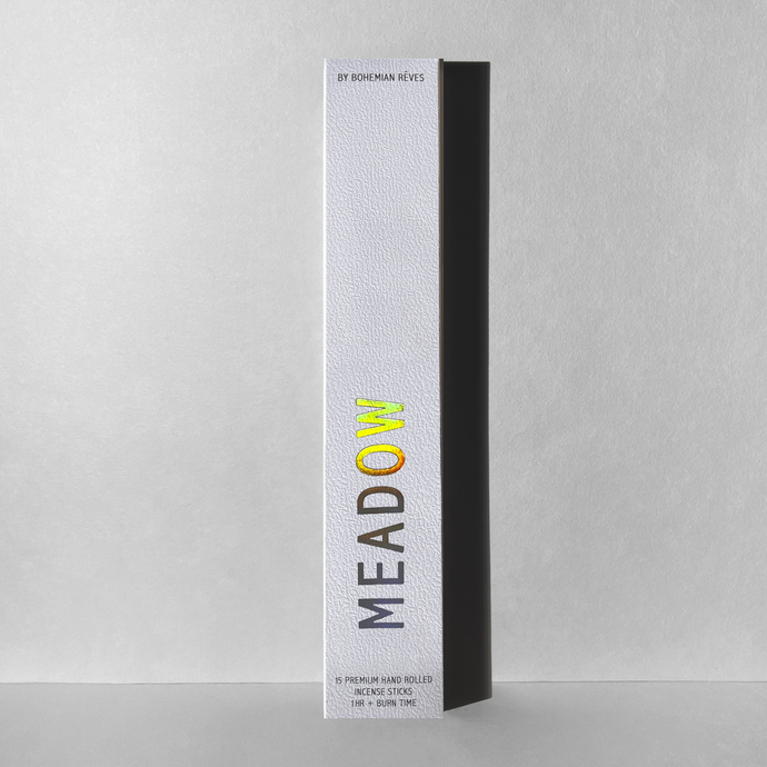 Meadow incense packaged in a white box with iridescent letters.