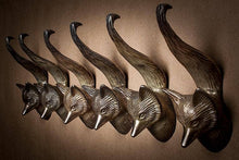 Load image into Gallery viewer, Set of brass fox head wall hooks on a brown background
