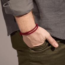 Load image into Gallery viewer, Close-up of a person wearing a red bracelet on their wrist.
