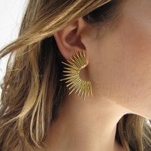 Load image into Gallery viewer, Close-up of a person wearing a gold sunburst earring.
