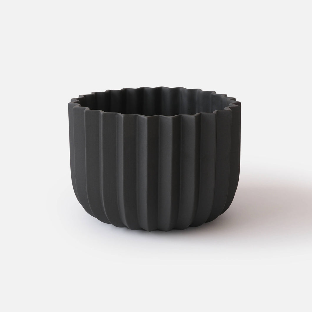 Black ribbed pot on a white background