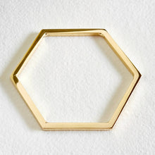 Load image into Gallery viewer, A gold hexagonal metal bracelet shown on a textured white background.
