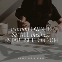 Load image into Gallery viewer, Person sitting at a table with a cup and notebook, text overlay about a woman-owned small business established in 2014, Sweet Water Decor branding.

