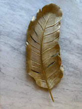 Load image into Gallery viewer, Gold feather-shaped object on a marble surface
