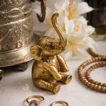 Load image into Gallery viewer, Gold elephant figurine on a surface with decorative items
