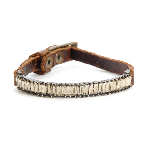 Brown leather bracelet with clear baguetter gemstones on a white background