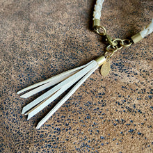 Load image into Gallery viewer, Bracelet with tassels and gold clasp on a textured brown surface

