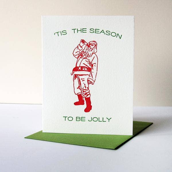 A holiday card with a cartoon illustration of a man in a Santa hat holding a bottle, and the text 'tis the season to be jolly'.