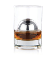 Load image into Gallery viewer, A stainless steel sphere floating in a glass of whiskey on a white background
