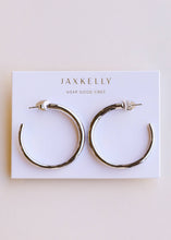 Load image into Gallery viewer, silver hoop earrings on a 'JaxKelly' branded card

