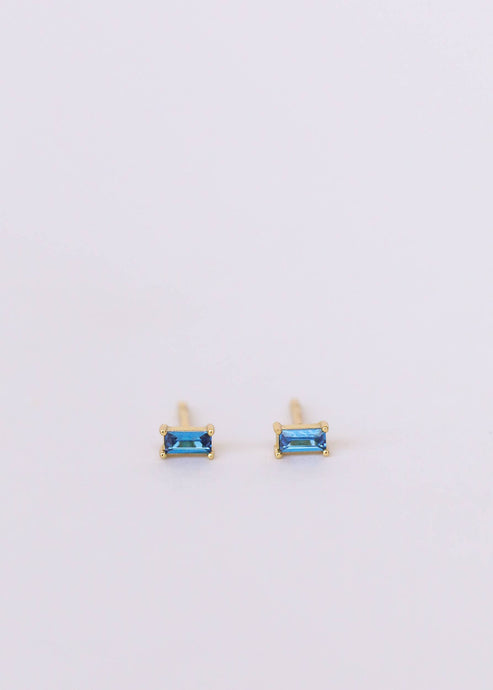 A pair of baguette-cut sapphire earrings with a gold vermeil sterling silver base, displayed against a white background.